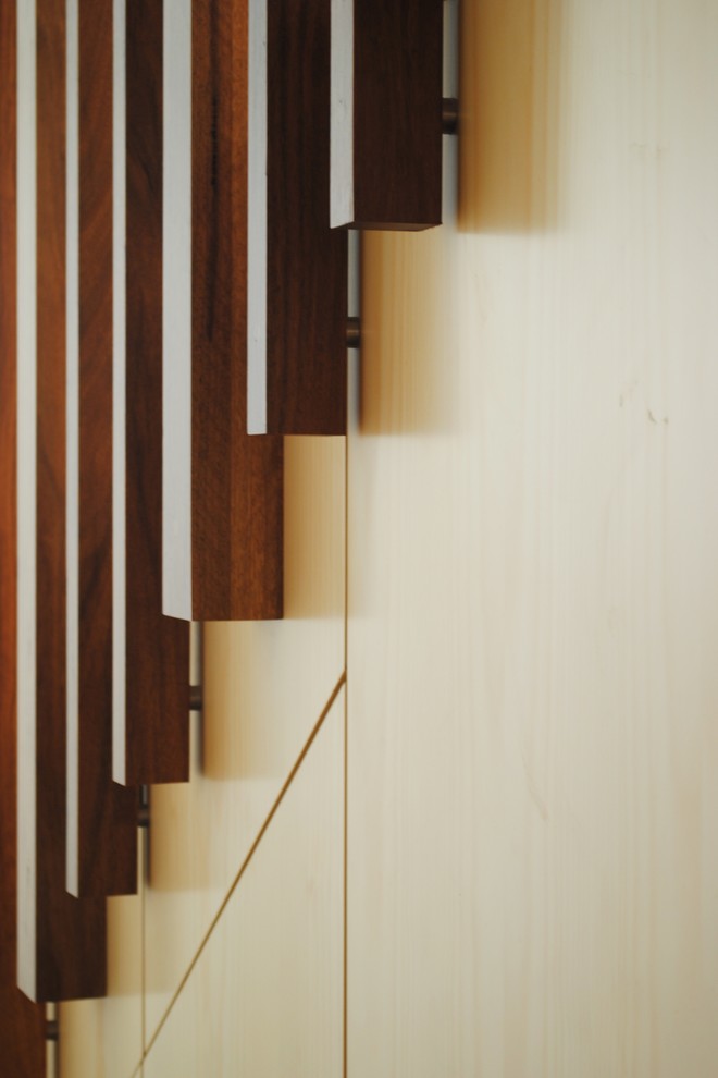 Imagen de escalera recta moderna pequeña con escalones de madera, contrahuellas de madera y barandilla de metal