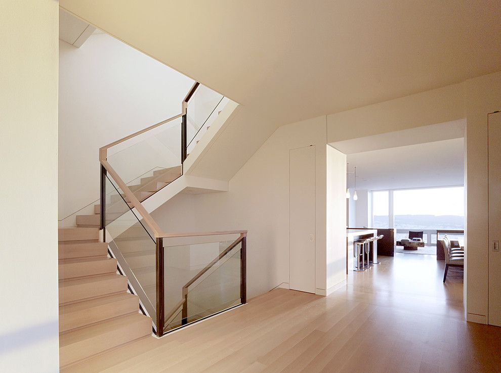 На фото: п-образная лестница в стиле модернизм с стеклянными перилами