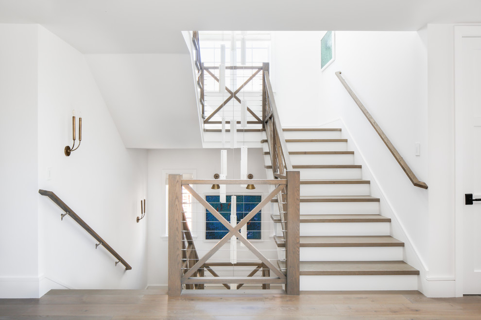 Стильный дизайн: п-образная лестница в морском стиле с деревянными ступенями, крашенными деревянными подступенками и перилами из тросов - последний тренд