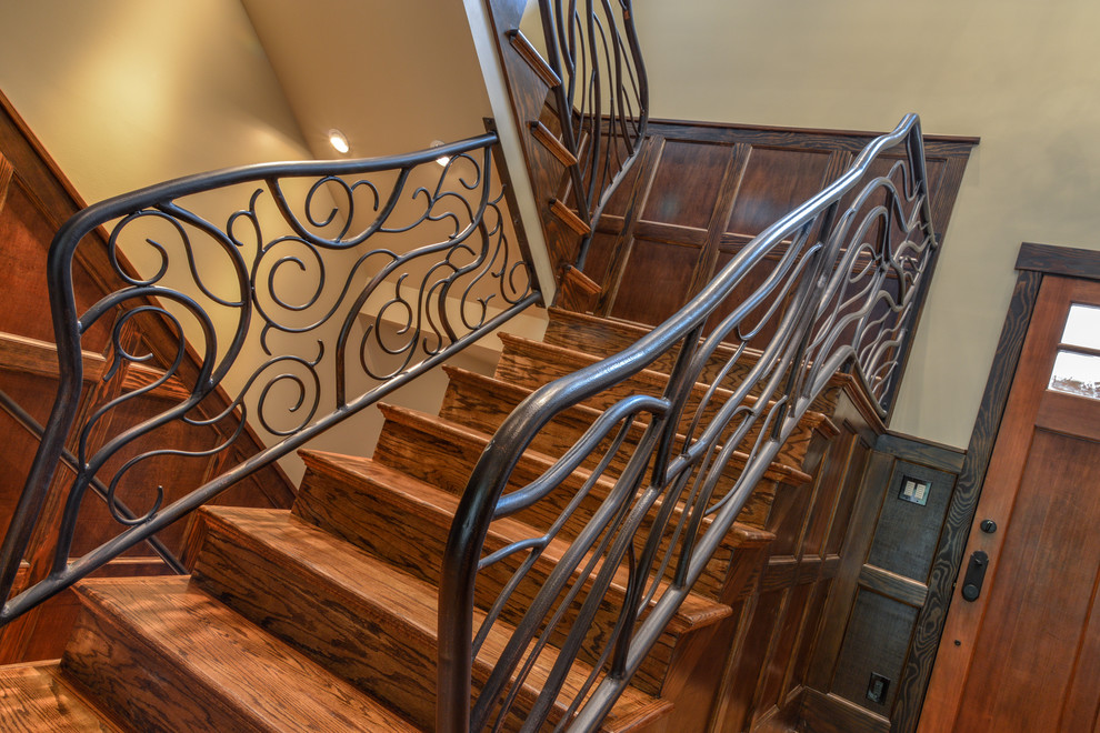 Imagen de escalera en U rústica grande con escalones de madera, contrahuellas de madera y barandilla de metal