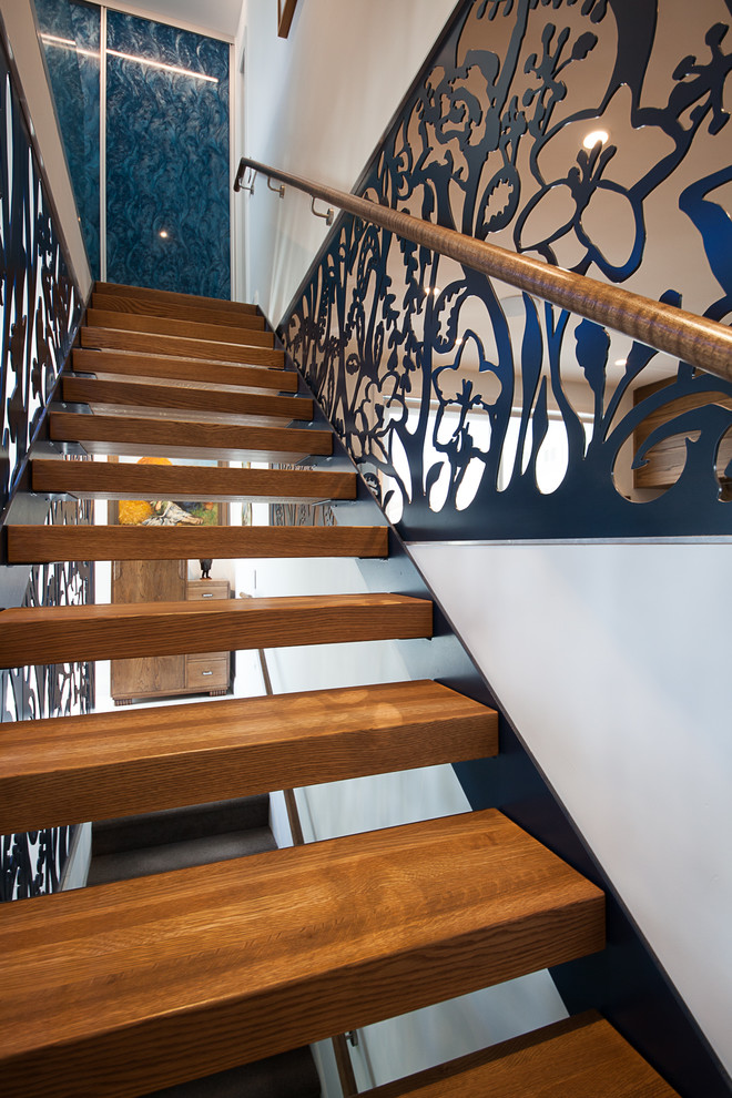 Ejemplo de escalera suspendida contemporánea de tamaño medio sin contrahuella con escalones de madera y barandilla de madera