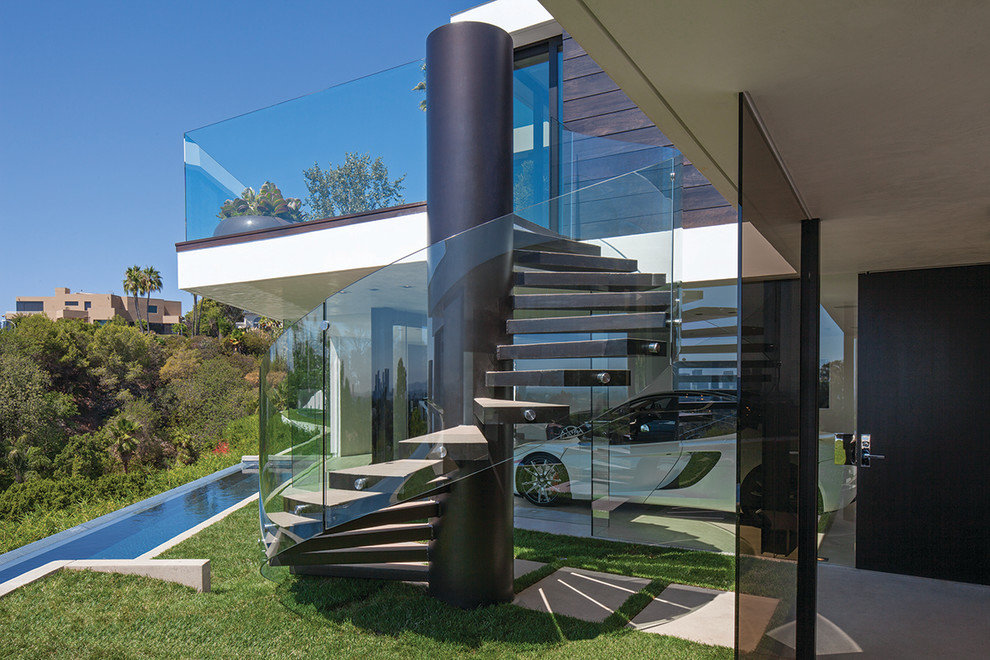 Идея дизайна: огромная винтовая лестница в современном стиле с стеклянными перилами без подступенок