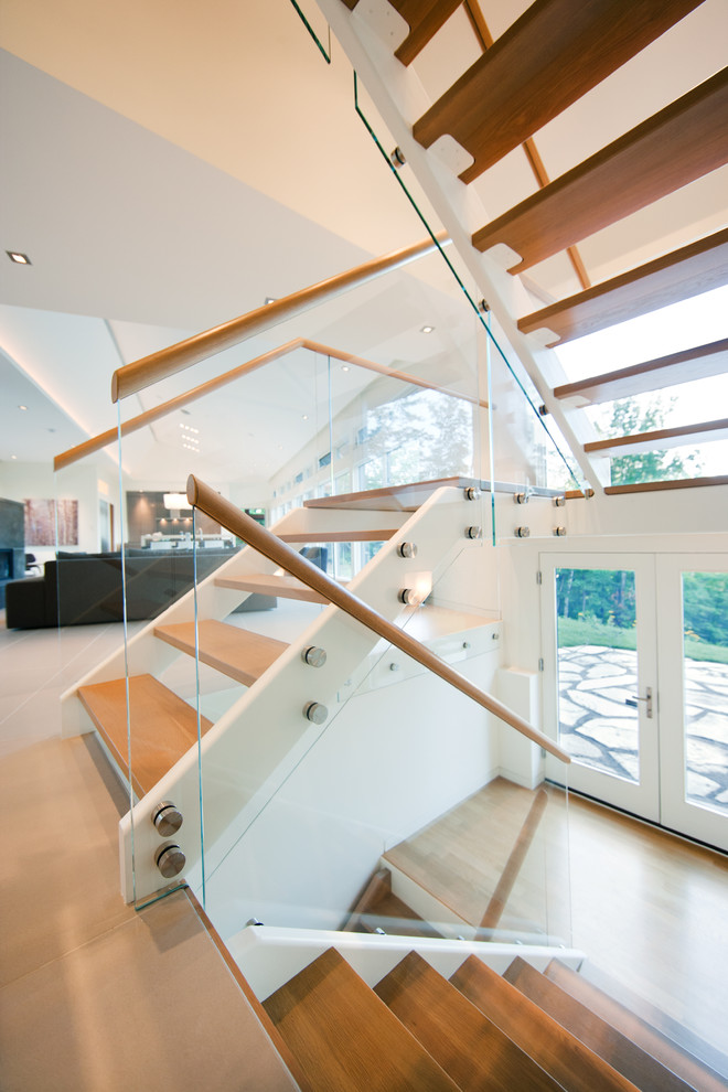 This is an example of a contemporary wood u-shaped staircase in Ottawa with open risers.