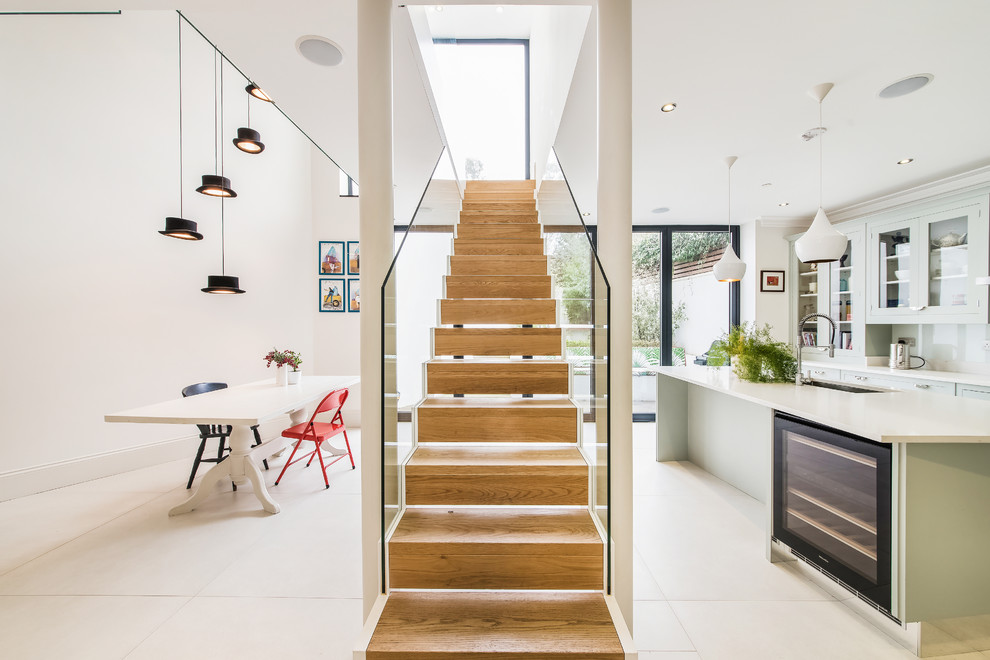 Idée de décoration pour un escalier droit design de taille moyenne avec des contremarches en bois et éclairage.