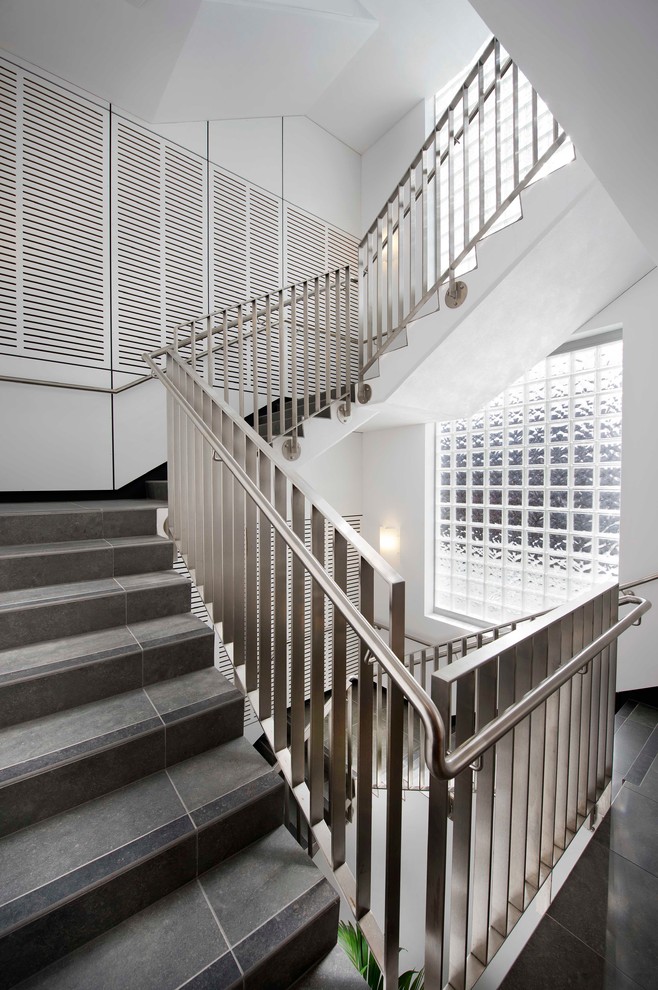 Источник вдохновения для домашнего уюта: п-образная лестница в современном стиле с ступенями из плитки и подступенками из плитки