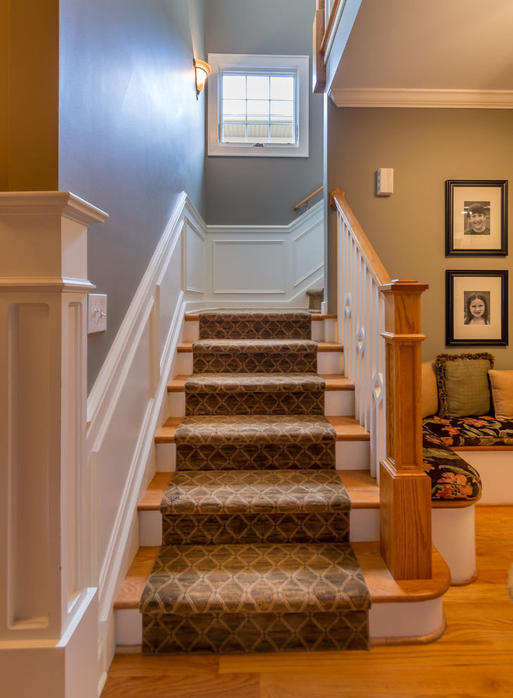 На фото: маленькая угловая лестница в классическом стиле с деревянными ступенями, крашенными деревянными подступенками, деревянными перилами и панелями на части стены для на участке и в саду
