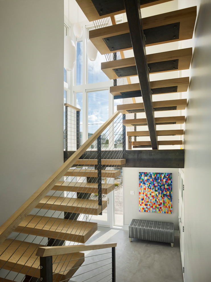 Imagen de escalera suspendida contemporánea pequeña sin contrahuella con escalones de madera y barandilla de metal