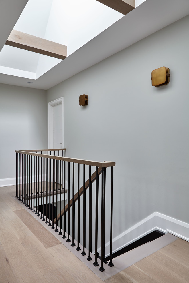 Diseño de escalera minimalista sin contrahuella con escalones de madera y barandilla de metal