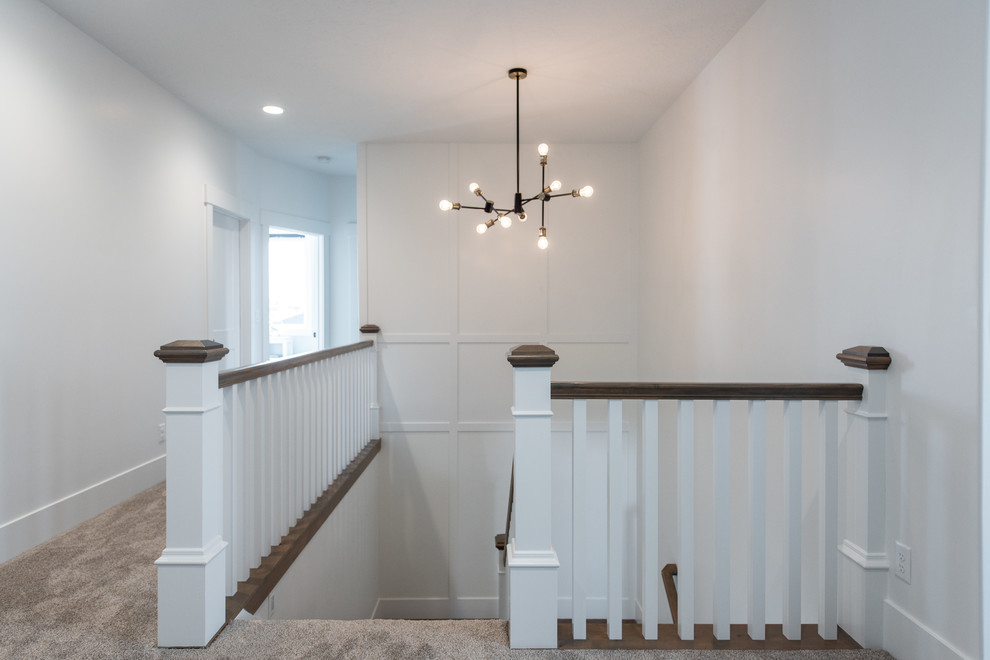 Imagen de escalera en U clásica renovada de tamaño medio con escalones de madera, contrahuellas de madera y barandilla de madera