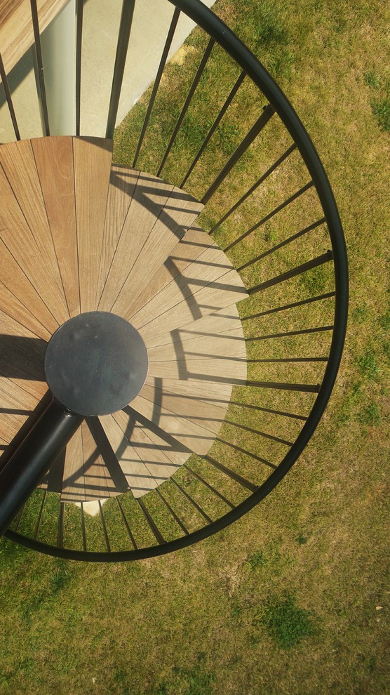 Esempio di una scala a chiocciola contemporanea di medie dimensioni con pedata in legno e nessuna alzata