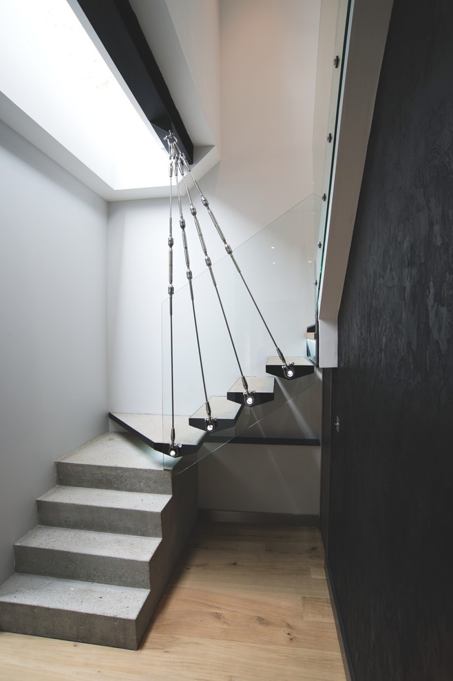 Diseño de escalera en U actual de tamaño medio con escalones de hormigón y contrahuellas de hormigón