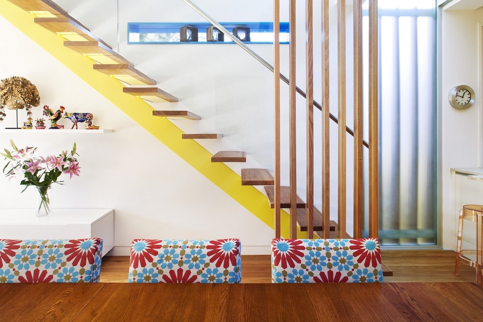 Idée de décoration pour un escalier sans contremarche droit design avec des marches en bois et un garde-corps en verre.