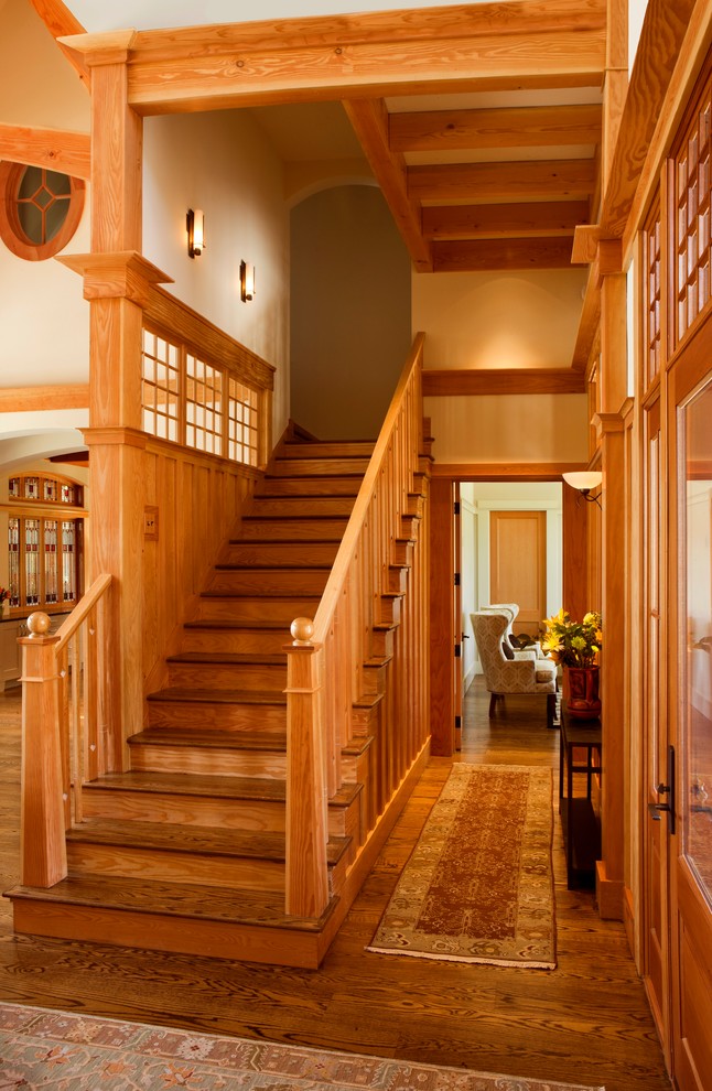 Источник вдохновения для домашнего уюта: большая угловая деревянная лестница в стиле кантри с деревянными ступенями и деревянными перилами