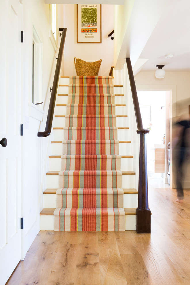 На фото: угловая деревянная лестница среднего размера в стиле кантри с деревянными ступенями и деревянными перилами