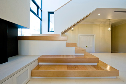 Diseño de escalera en U actual de tamaño medio con escalones de madera y contrahuellas de madera pintada