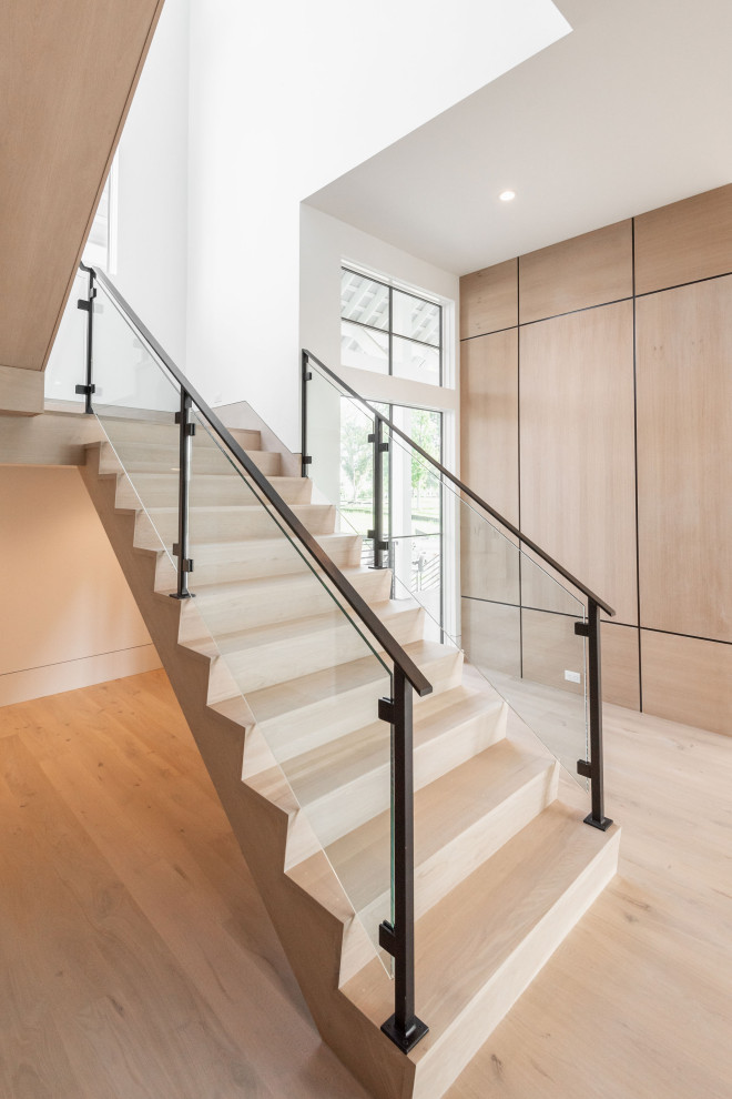 Ejemplo de escalera en L minimalista grande con escalones de madera, contrahuellas de madera, barandilla de metal y madera