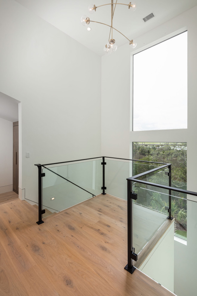 Ejemplo de escalera en L moderna grande con escalones de madera, contrahuellas de madera, barandilla de metal y madera