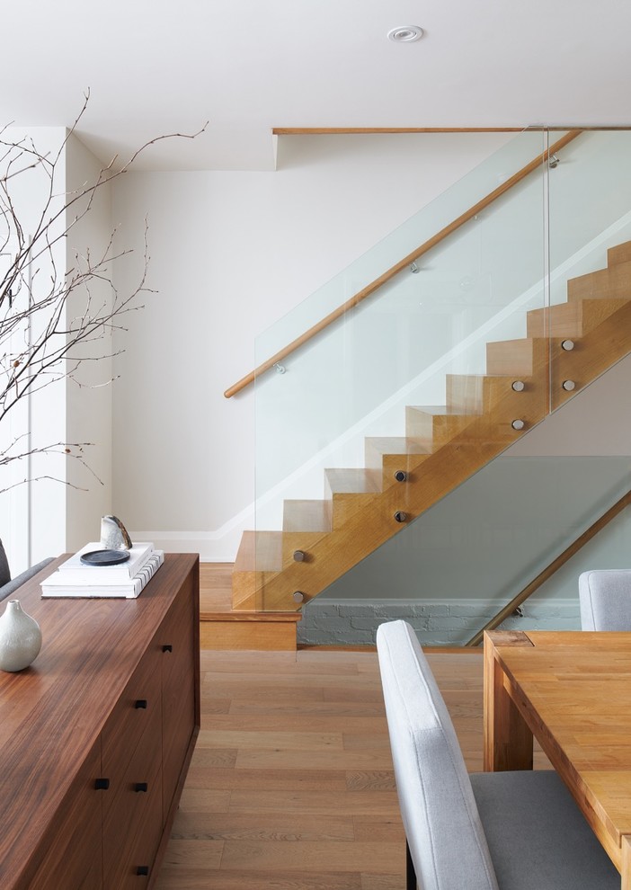 Ejemplo de escalera recta contemporánea de tamaño medio con escalones de madera, contrahuellas de madera y barandilla de vidrio