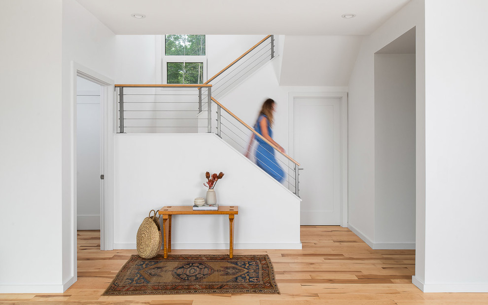 Diseño de escalera en U nórdica con escalones de madera y barandilla de cable