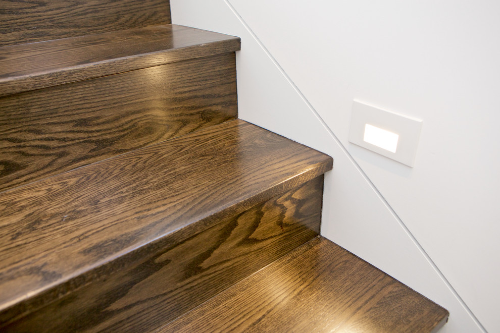 Imagen de escalera en U moderna de tamaño medio con escalones de madera, contrahuellas de madera y barandilla de vidrio
