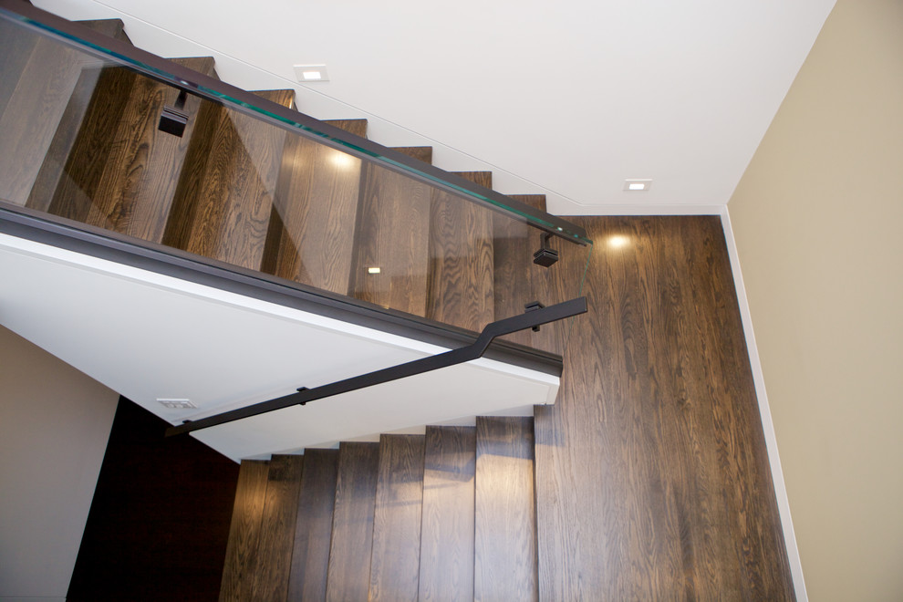 Diseño de escalera en U minimalista de tamaño medio con escalones de madera, contrahuellas de madera y barandilla de vidrio