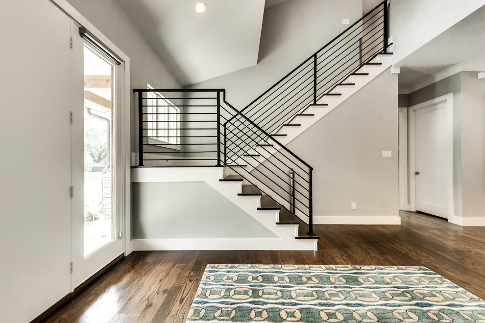 This is an example of a farmhouse wood u-shaped metal railing staircase in Dallas with painted wood risers.