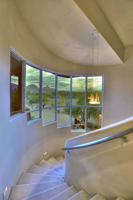 Expansive midcentury carpeted spiral staircase in Phoenix with carpeted risers.