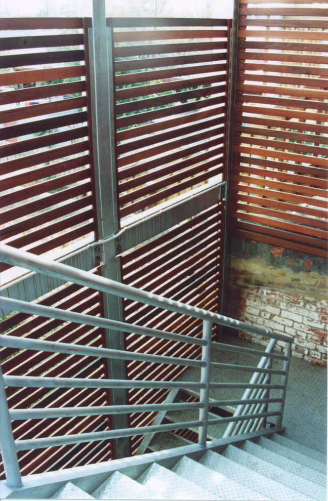 Foto de escalera en U ecléctica de tamaño medio sin contrahuella con escalones de metal y barandilla de metal