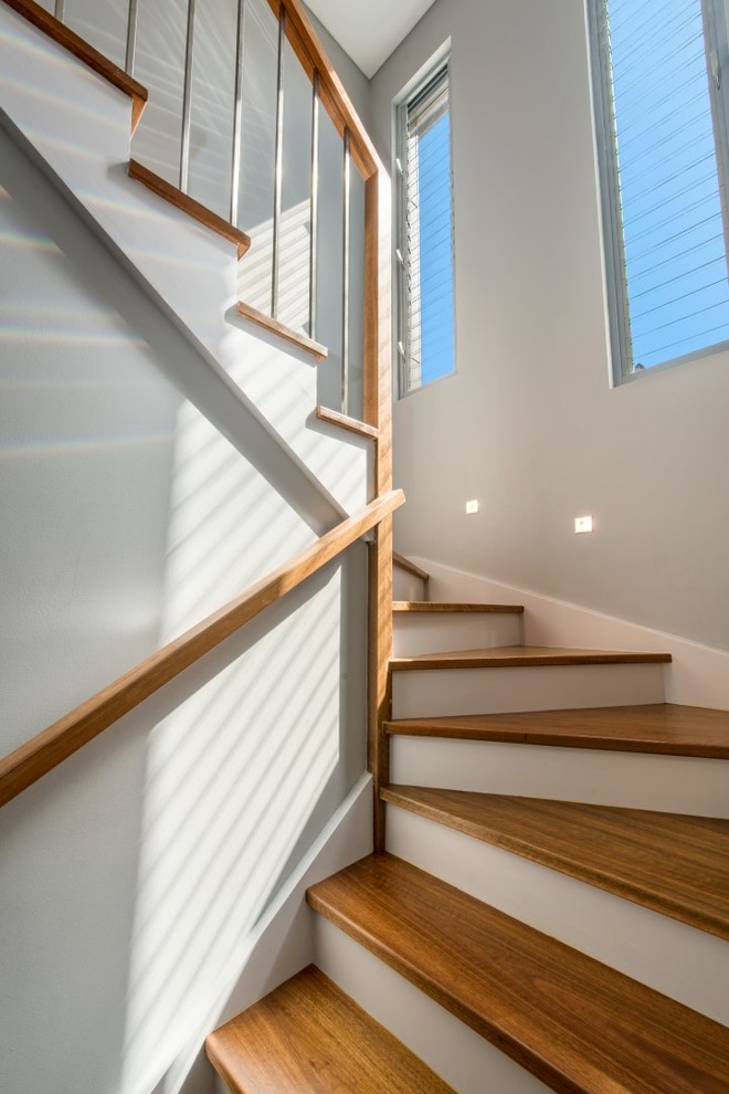 Свежая идея для дизайна: п-образная лестница среднего размера в современном стиле с деревянными ступенями и крашенными деревянными подступенками - отличное фото интерьера
