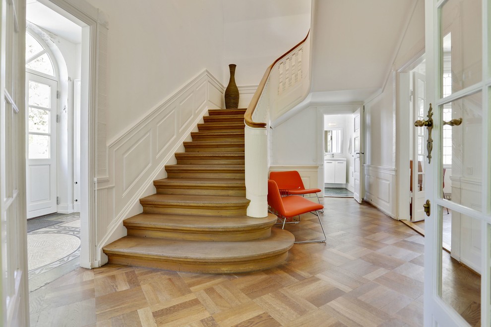 Idée de décoration pour un grand escalier tradition en U avec des marches en bois et des contremarches en bois.