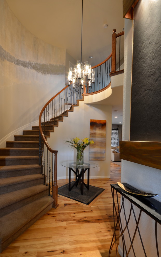 На фото: изогнутая лестница в классическом стиле с ступенями с ковровым покрытием и ковровыми подступенками с