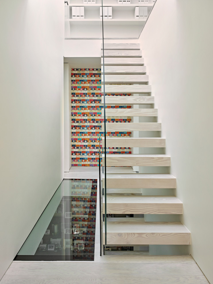 На фото: прямая лестница в стиле модернизм с деревянными ступенями и стеклянными перилами без подступенок с