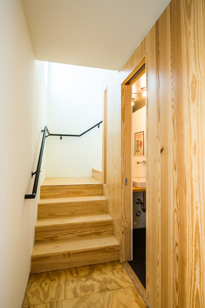 Cette image montre un escalier vintage en L de taille moyenne avec des marches en bois, des contremarches en bois et un garde-corps en métal.