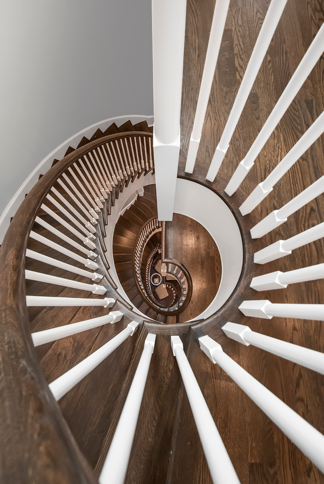 Inspiration for a large timeless wooden curved staircase remodel in Chicago with painted risers