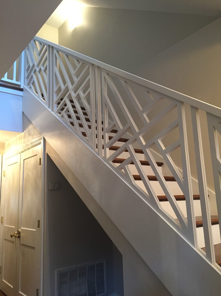 На фото: большая п-образная лестница в стиле неоклассика (современная классика) с крашенными деревянными ступенями, крашенными деревянными подступенками и деревянными перилами