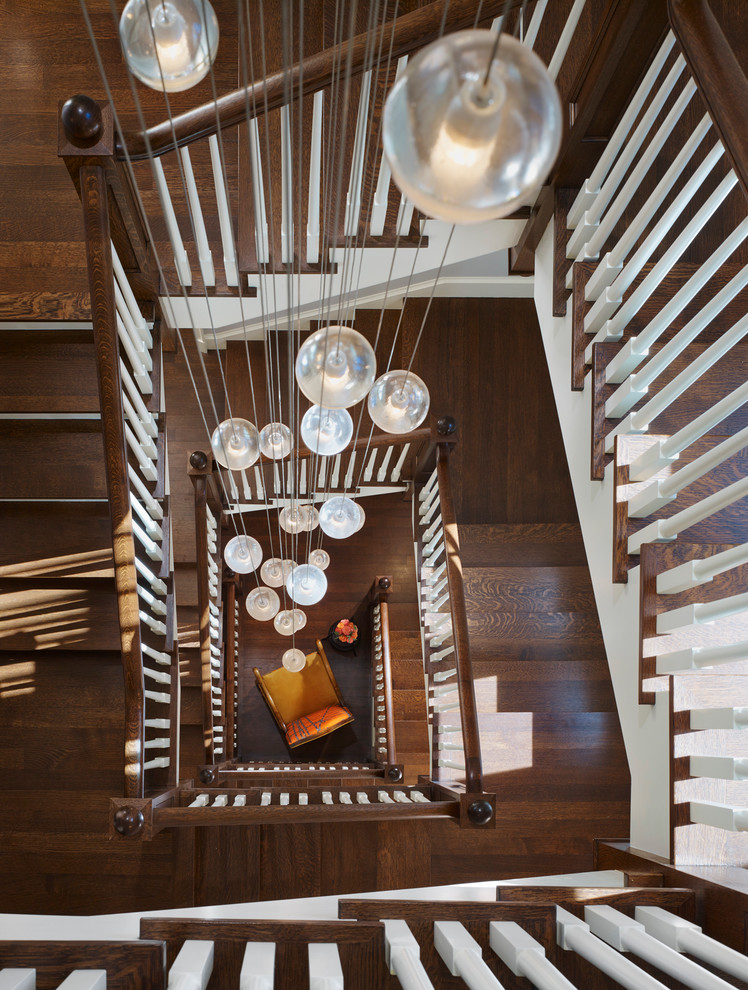 Imagen de escalera de caracol clásica grande con escalones de madera y contrahuellas de madera pintada