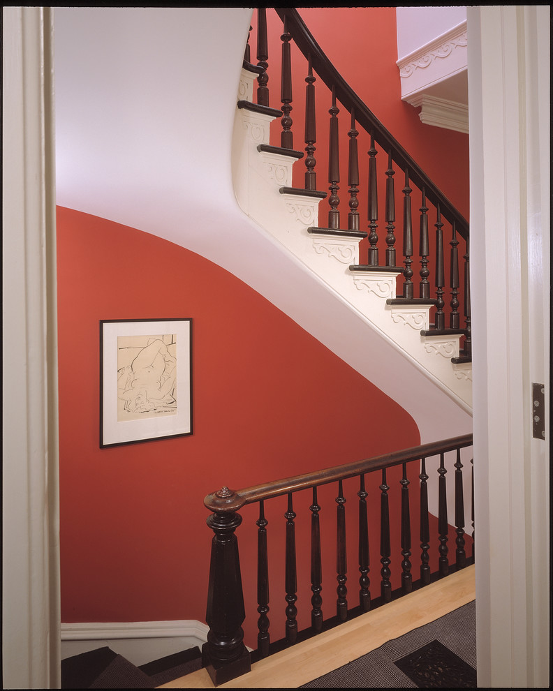 Cette photo montre un grand escalier courbe tendance avec des marches en moquette, des contremarches en moquette et un garde-corps en bois.