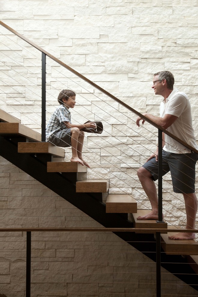 Example of a trendy wooden cable railing and open staircase design in Minneapolis