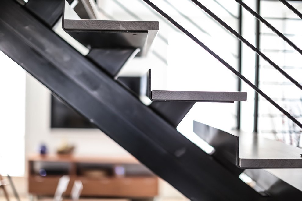 Ejemplo de escalera en L minimalista sin contrahuella con escalones de madera