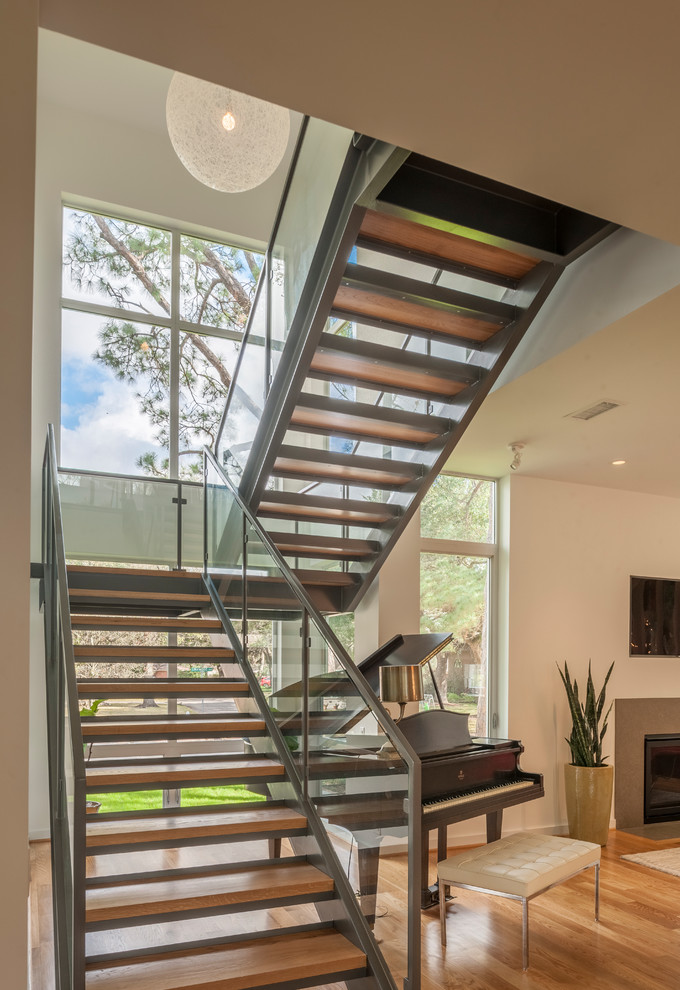 На фото: п-образная лестница среднего размера в стиле модернизм с деревянными ступенями без подступенок