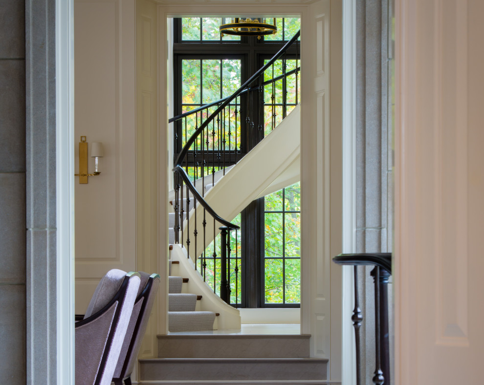 Photo of a large classic wood curved metal railing staircase in DC Metro with painted wood risers.