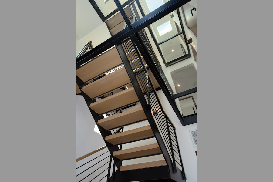 Contemporary wood u-shaped metal railing staircase in Los Angeles with wood risers.