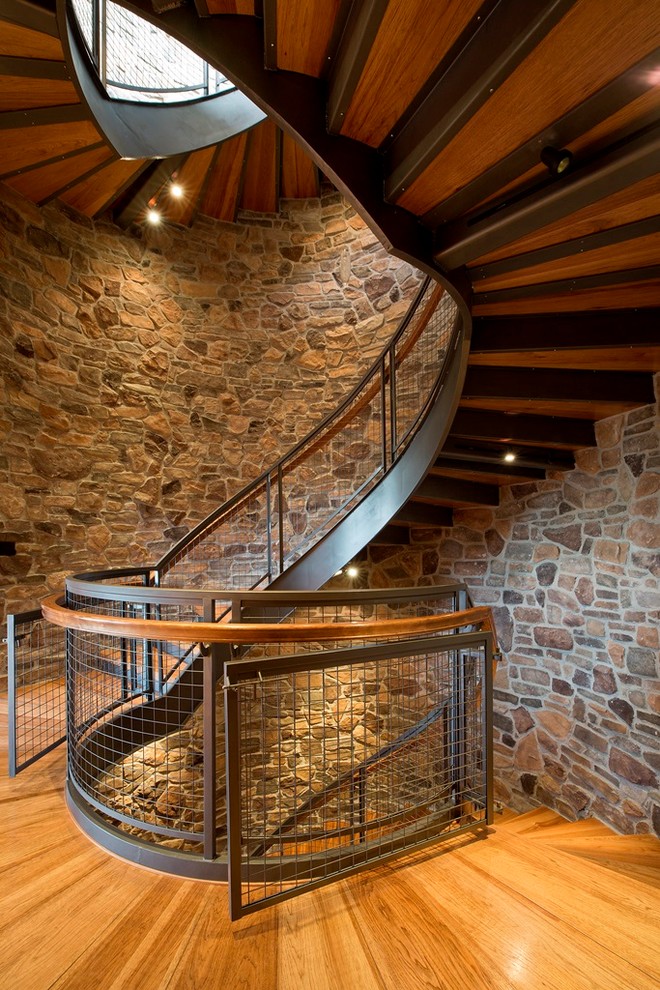Ejemplo de escalera curva rústica grande con escalones de madera