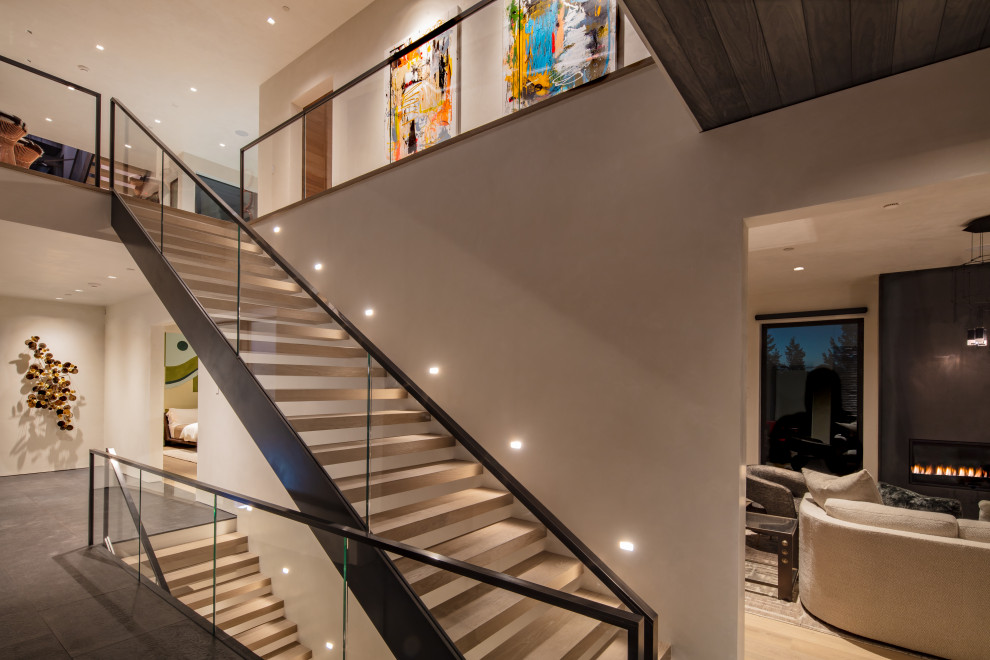 Expansive contemporary wood straight glass railing staircase in Denver with open risers.