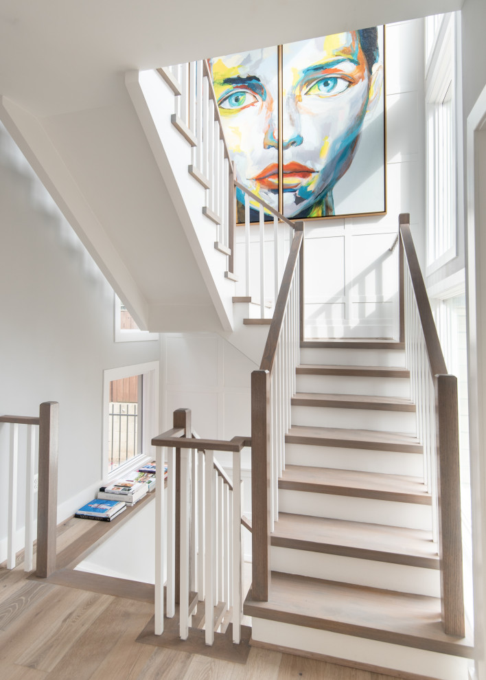 На фото: п-образная лестница в стиле неоклассика (современная классика) с деревянными ступенями, крашенными деревянными подступенками и деревянными перилами