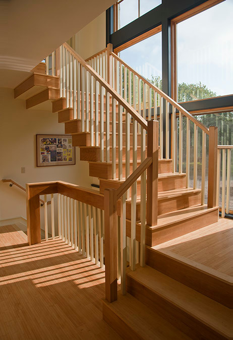 На фото: большая п-образная деревянная лестница в классическом стиле с деревянными ступенями с