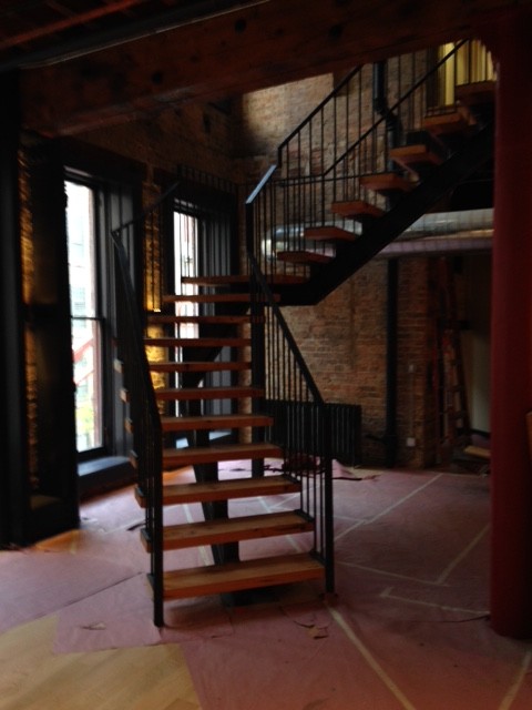 Aménagement d'un escalier sans contremarche flottant industriel avec des marches en bois.