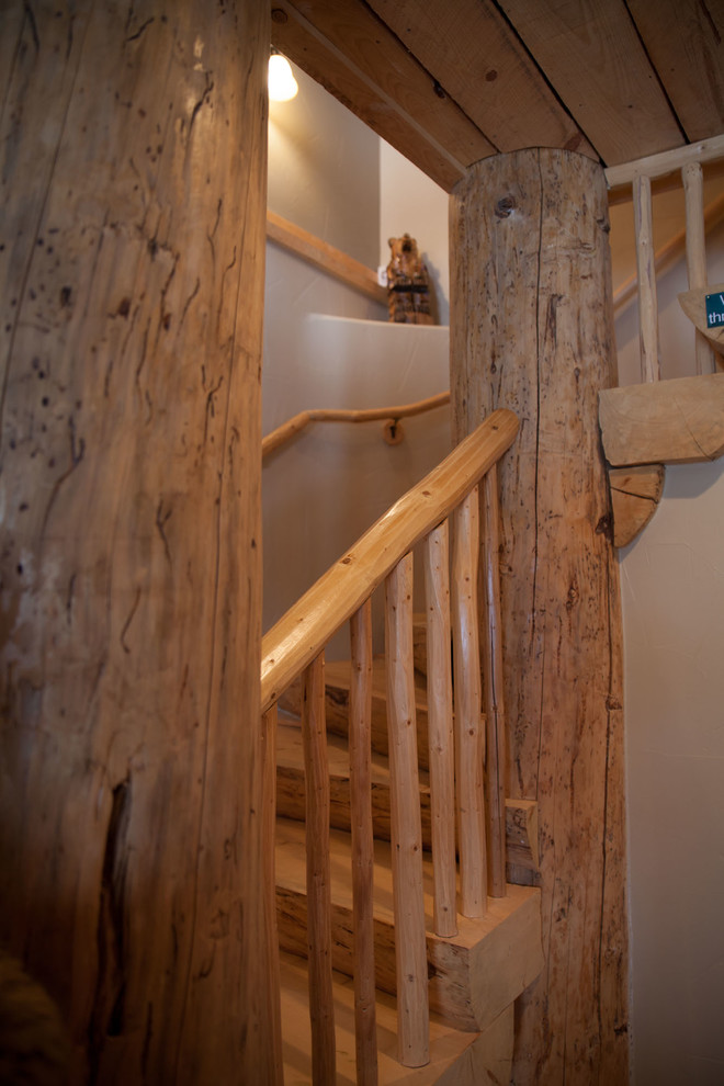 Foto de escalera en U rústica de tamaño medio con escalones de madera, contrahuellas de madera y barandilla de madera
