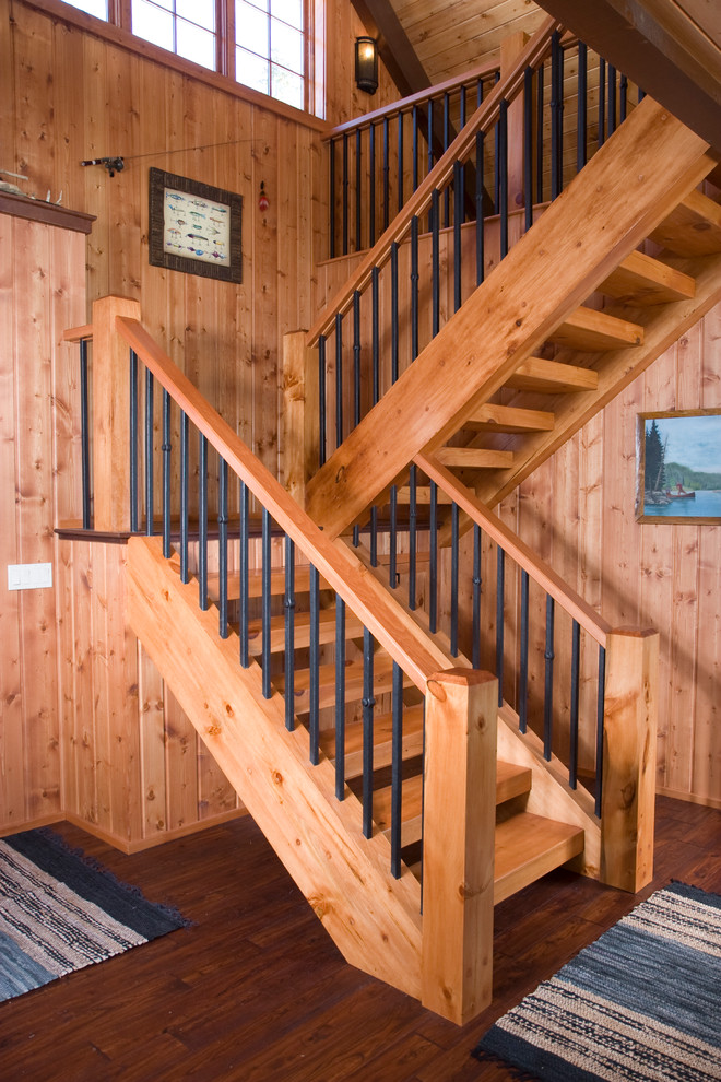 На фото: большая угловая деревянная лестница в стиле рустика с деревянными ступенями с