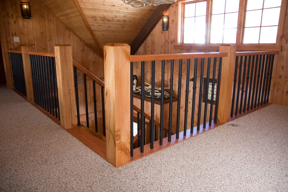Photo of a large rustic wood l-shaped staircase in Other with wood risers.